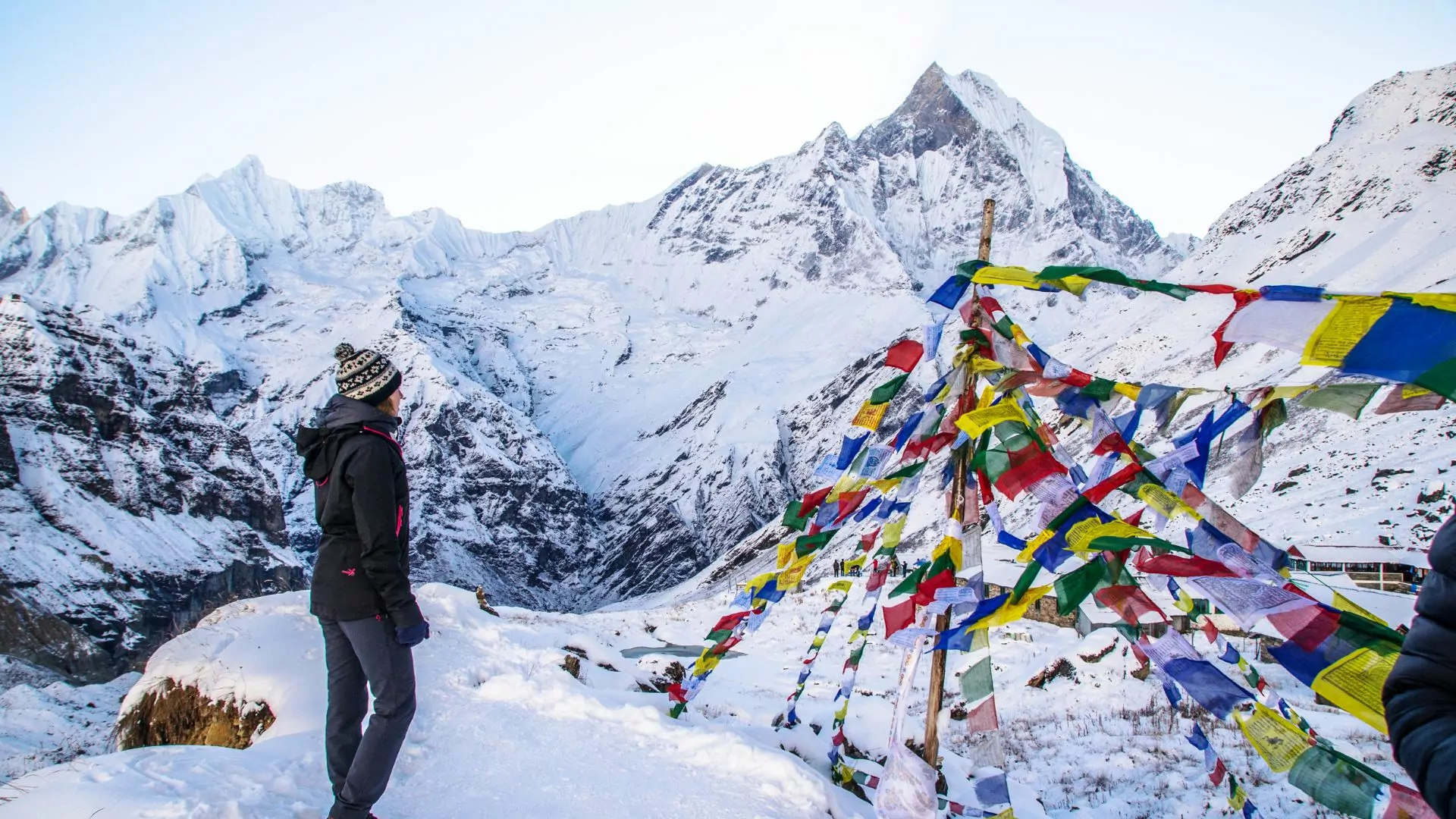 A woman poses in the snowy Himalaya mountains at Annapurna Basecamp