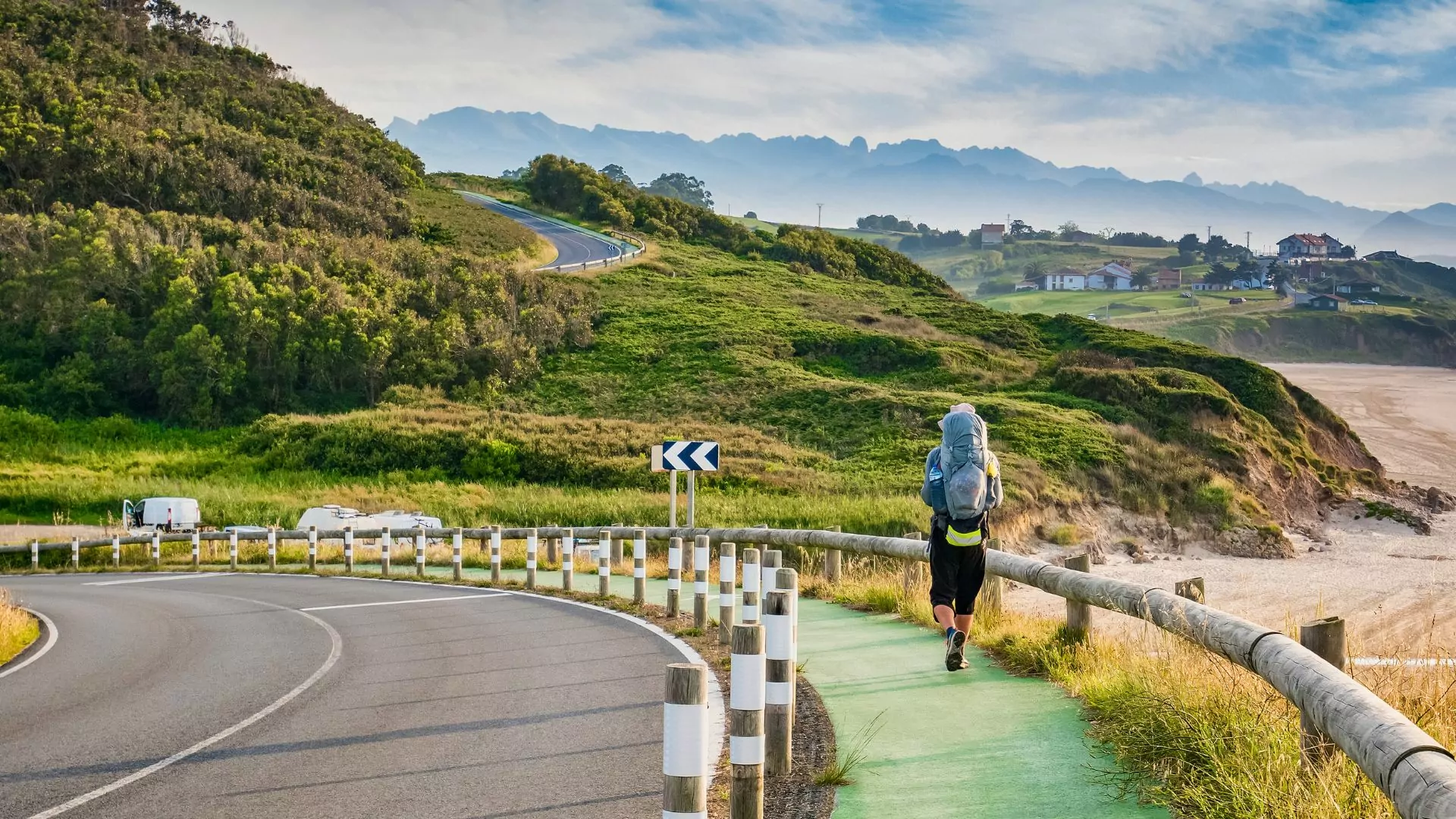 A backpacker hikes down the Camino de Santiago along the coast of Spain