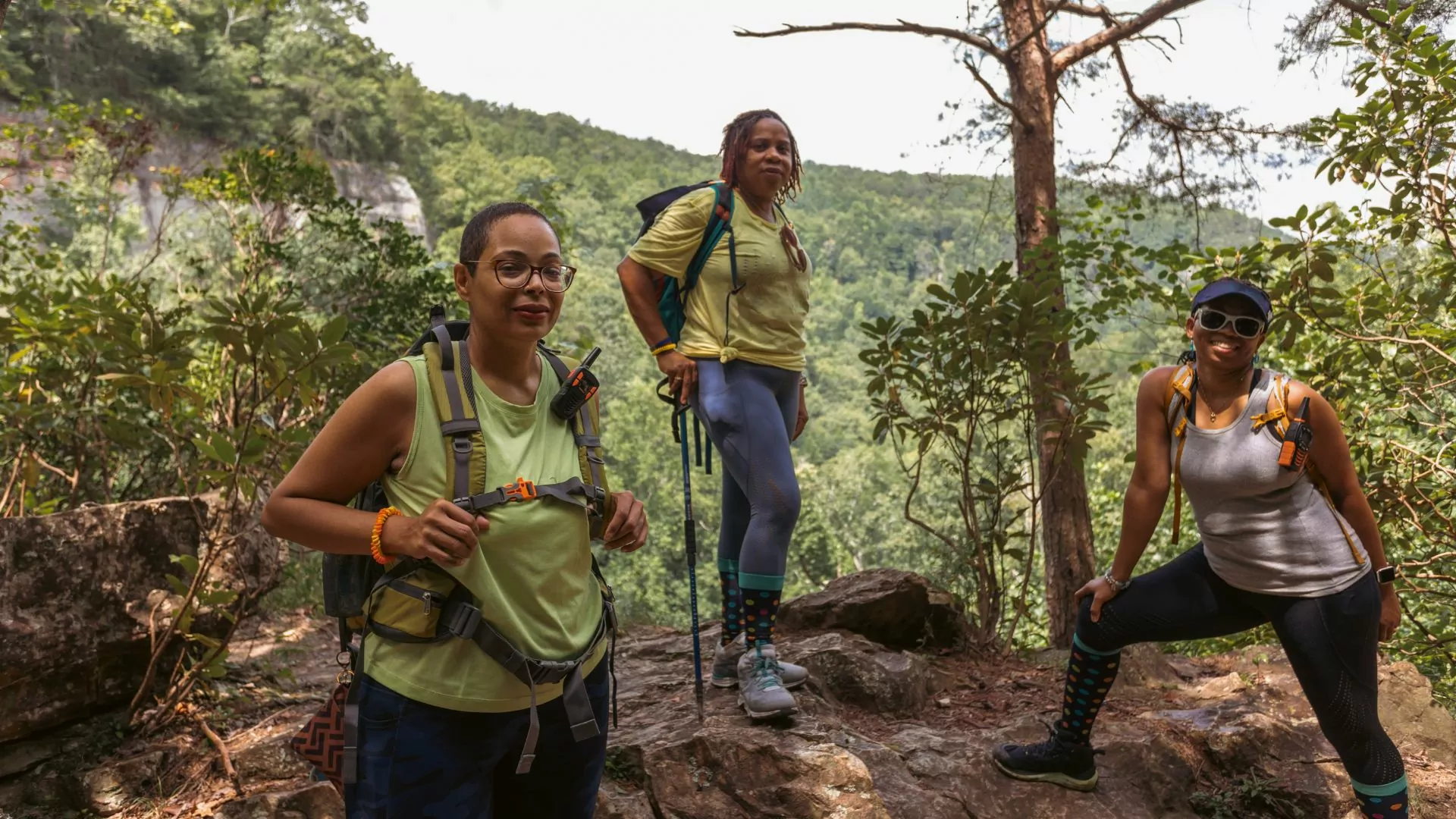 Three women dressed for hiking pose together outside